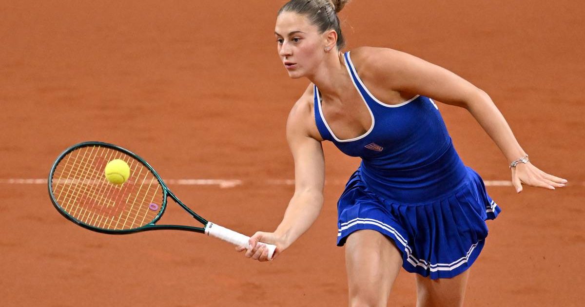Tenisistka Marta Kostiuk uderza piłkę rakietą podczas meczu na kortach ziemnych.